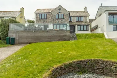 a house with a large lawn in front of it at Pentewan in Polzeath