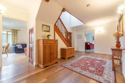 an open living room with a staircase and a rug at September Cottage in Wadebridge