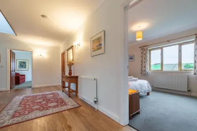 a living room with a bed and a window at September Cottage in Wadebridge