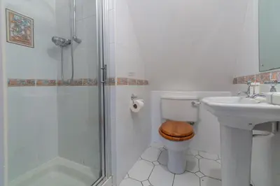 a bathroom with a toilet and a sink and a shower at September Cottage in Wadebridge