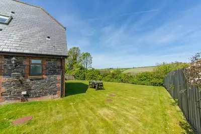 a garden with a picnic table in front of a house at September Cottage in Wadebridge