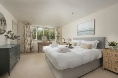 a bedroom with a large white bed and a desk at The Nineteenth in Wadebridge
