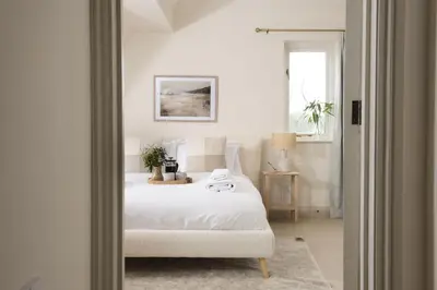 a bedroom with a white bed and a window at The Nineteenth in Wadebridge