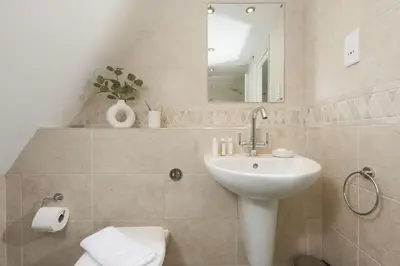 a bathroom with a sink and a toilet and a mirror at The Nineteenth in Wadebridge