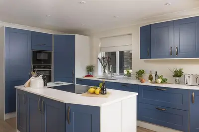 a kitchen with blue cabinets and white counter tops at The Nineteenth in Wadebridge