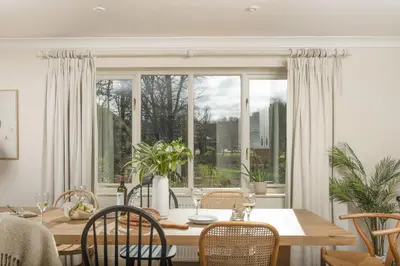 a dining room with a table and a large window at The Nineteenth in Wadebridge