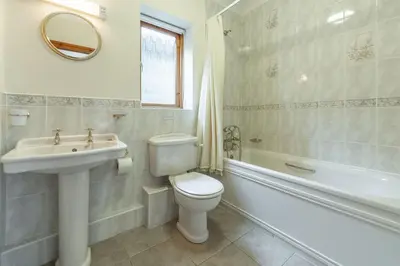 a bathroom with a toilet and a sink and a tub at Webbs Retreat in Wadebridge