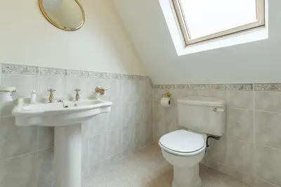 a bathroom with a toilet and a sink at Webbs Retreat in Wadebridge