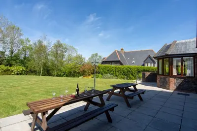 a patio with two picnic tables in a yard at Webbs Retreat in Wadebridge