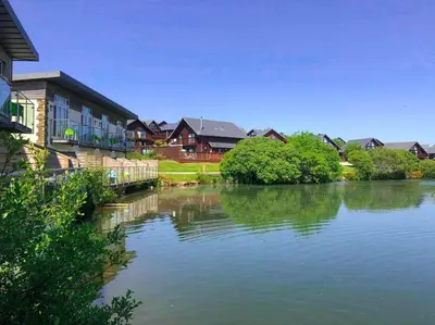 a river in front of some houses and trees at Retallack Resort by Away Resorts in Padstow