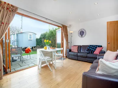 a living room with a couch and a table at Candles Cottage in Cubert
