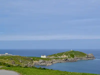 a house on a small island in the ocean at Candles Cottage in Cubert
