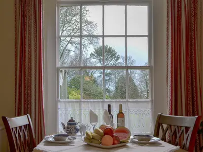 a table with a plate of fruit and a window at Isolda's - Ukc3905 in Lostwithiel