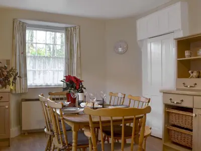 a dining room with a table and chairs and a window at Tristan's - Ukc3906 in Lostwithiel