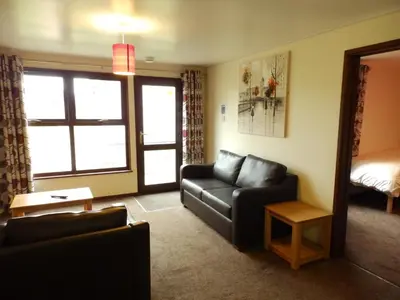 a living room with a couch and a bed at Perran View Holiday Park in St. Agnes