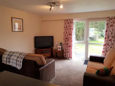 a living room with a couch and a tv and a window at Perran View Holiday Park in St. Agnes