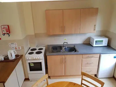 a small kitchen with a sink and a stove at Perran View Holiday Park in St. Agnes