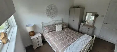 a bedroom with a bed with a mirror and a dresser at Perran View Holiday Park in St. Agnes