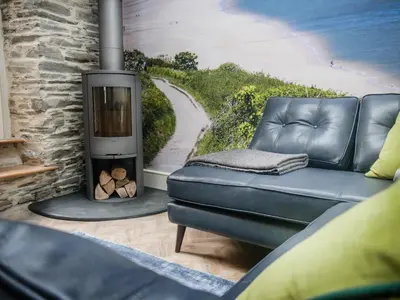 a living room with a couch and a fireplace at Padstow Escapes - The Long Room Luxury Apartment in Padstow