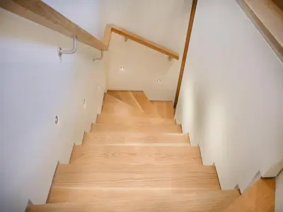 a staircase in a room with white walls and wooden floors at Padstow Escapes - The Long Room Luxury Apartment in Padstow