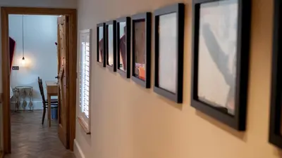 a hallway with a bunch of pictures on a wall at Padstow Escapes - The Long Room Luxury Apartment in Padstow