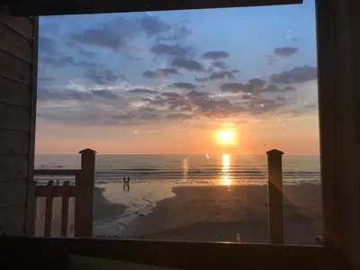 a view of a sunset from a window of a beach at Beachy in Newquay