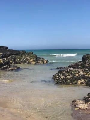a beach with some rocks and the ocean at Beachy in Newquay