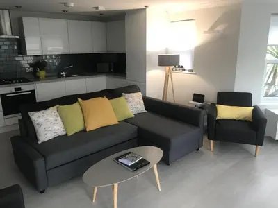 a living room with a couch and a table at Beachy in Newquay