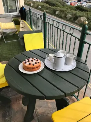 a green table with a donut on a plate at Beachy in Newquay