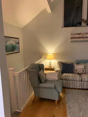 a living room with a chair and a couch at Bossiney Cove Cottage in Tintagel