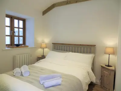 a bedroom with a bed with two towels on it at Quay Courtyard, on the harbour with free parking in Charlestown