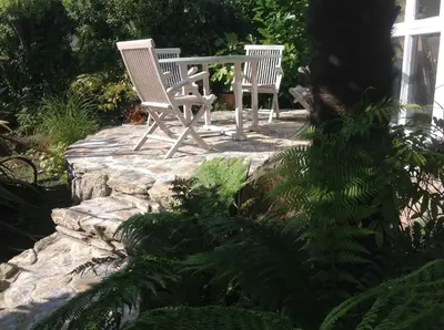 two chairs and a table sitting on a stone patio at Quay Courtyard, on the harbour with free parking in Charlestown