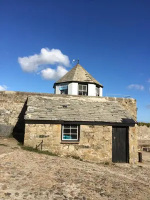 a stone building with a tower on top of it at Quay Courtyard, on the harbour with free parking in Charlestown