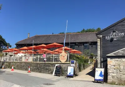 a restaurant with red umbrellas in front of a building at Quay Courtyard, on the harbour with free parking in Charlestown