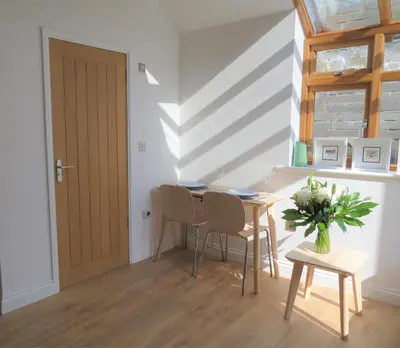 a dining room with a table and chairs and a door at Quay Courtyard, on the harbour with free parking in Charlestown