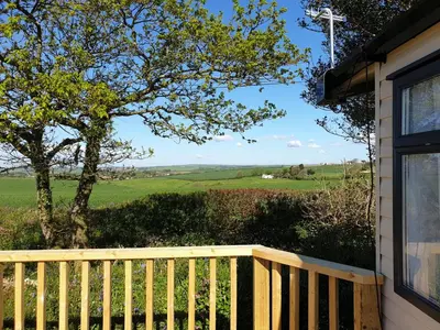 a view from the porch of a house with a wooden fence at Polborder Holidays Looe Country Park in Looe