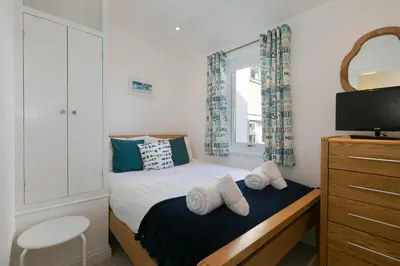 a small bedroom with a bed and a window at Sea Crest in St Ives
