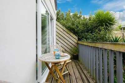 a small wooden table on the balcony of a house at Number One - Stones Court in St Ives