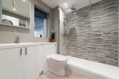 a bathroom with a white toilet and a stone wall at Number One - Stones Court in St Ives