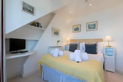 a bedroom with a bed with a tv on it at SeaCrest 2 in St Ives