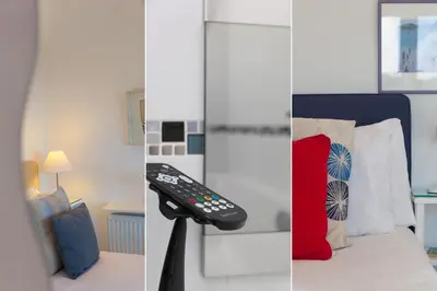 a remote control sitting on a stand next to a bed at SeaCrest 2 in St Ives