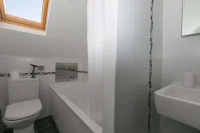 a white bathroom with a toilet and a sink at SeaCrest 2 in St Ives
