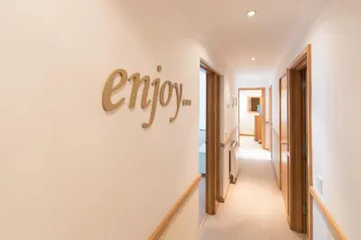 a hallway with a sign that reads enjoy on the wall at Marine Point, Mevagissey - sensational cliff top views of harbour and bay in Mevagissey