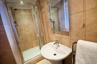 a bathroom with a sink and a shower at Marine Point, Mevagissey - sensational cliff top views of harbour and bay in Mevagissey