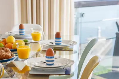 a table topped with plates of eggs and fruit at Marine Point, Mevagissey - sensational cliff top views of harbour and bay in Mevagissey