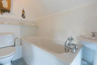 a bathroom with a tub and a toilet and a sink at Whistler's Rest in St Ives