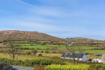 a view of a field with a hill in the background at Whistler's Rest in St Ives