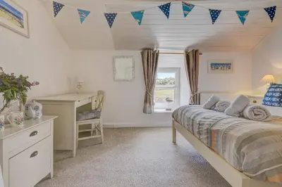 a bedroom with a bed and a desk and a window at Whistler's Rest in St Ives