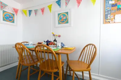 a dining room table with four chairs and flags at 85 Back Road East in St Ives
