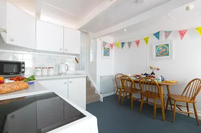 a kitchen and dining room with a table and chairs at 85 Back Road East in St Ives